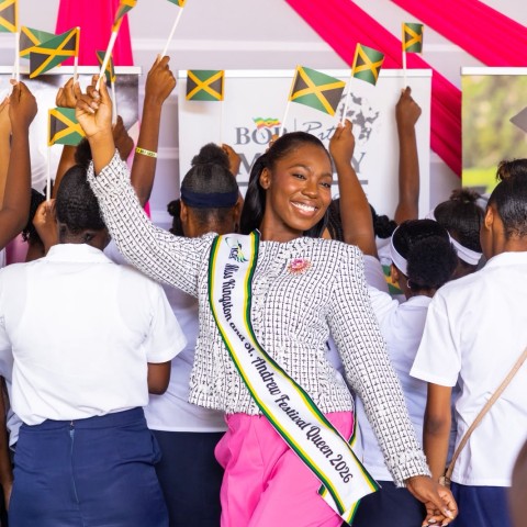 The 2026 Kingston and St. Andrew Festival Queen, Danielle Cox, celebrates with young mothers waving Jamaican flags during the launch of her community project, aimed at empowering teenage mothers through education, mentorship and personal development.