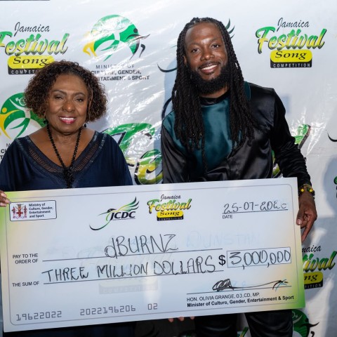 Minister of Culture, Gender, Entertainment and Sport, the Honourable Olivia Grange (left), presents the $3-million grand prize to 2026 Jamaica Festival Song Competition winner dBURNZ. Entries for the JCDC’s 2027 competitions officially open on November 1, offering Jamaicans another opportunity to showcase their talents.